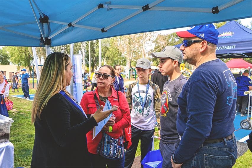 A LionsCrest representative speaking with residents at a community event