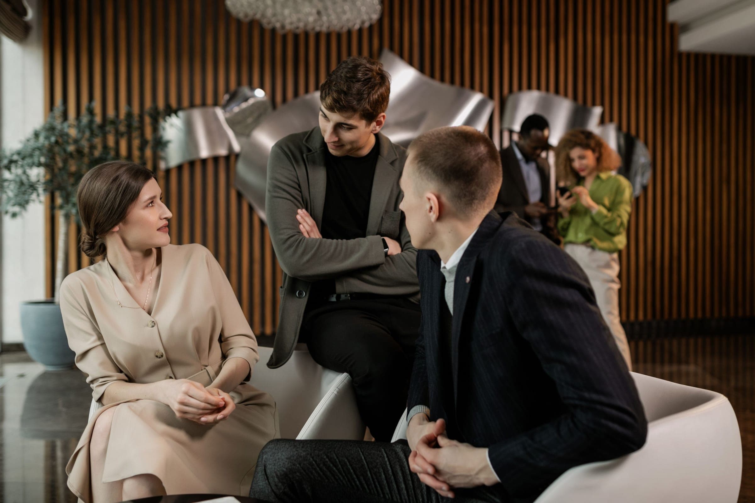 Three colleagues in conversation in a modern lobby
