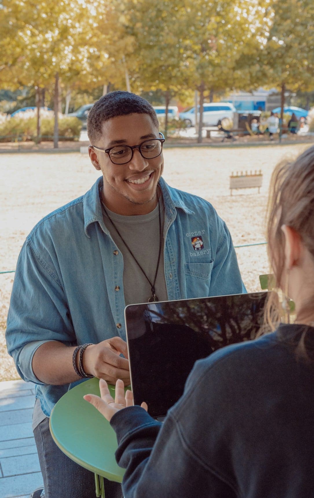 A field representative talking with a community member over a laptop